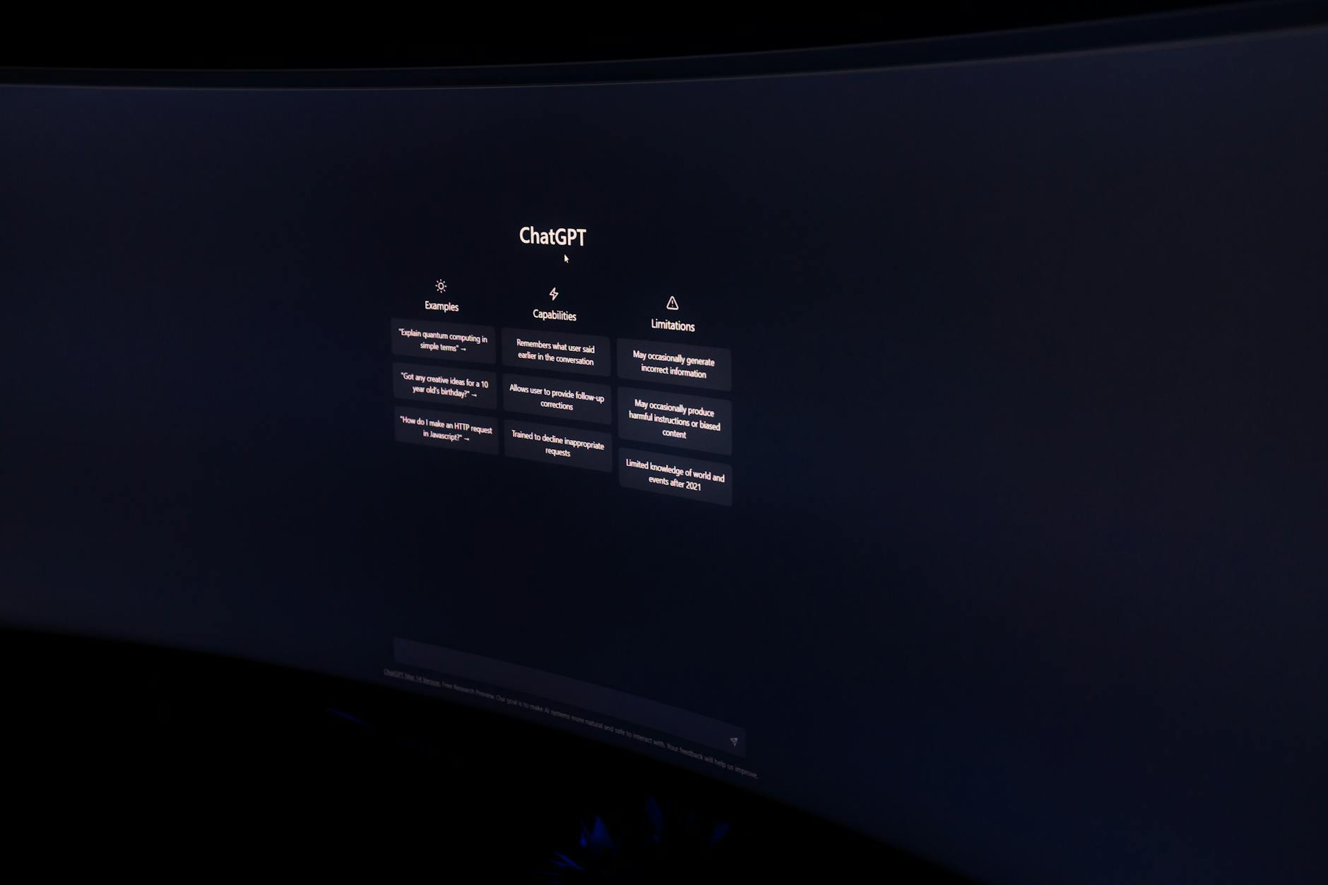 A dark, minimalist photo of a computer monitor displaying the ChatGPT interface.